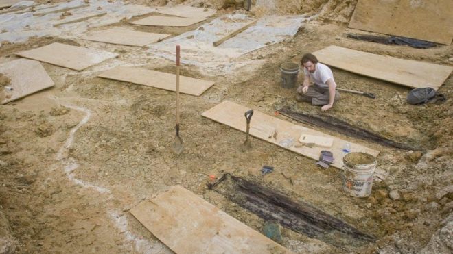 researchers unearthing coffins