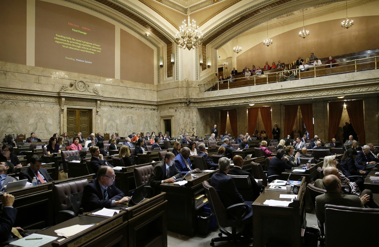 Representatives work on the House floor during discussion of a bill to fully fund education in Washington state at the Capitol in Olympia, Wash., in late June. (Ted S. Warren/AP)